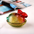 Side view of multi-colored glass rabbit lidded dish