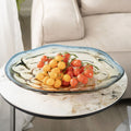 Blue and amber gradient glass bowl with organic rim holding tomatoes
