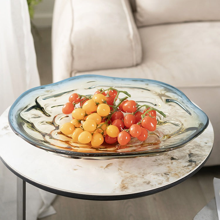 Blue and amber gradient glass bowl with organic rim holding tomatoes