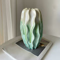 Large gradient sculptural ceramic vase resting on a magazine