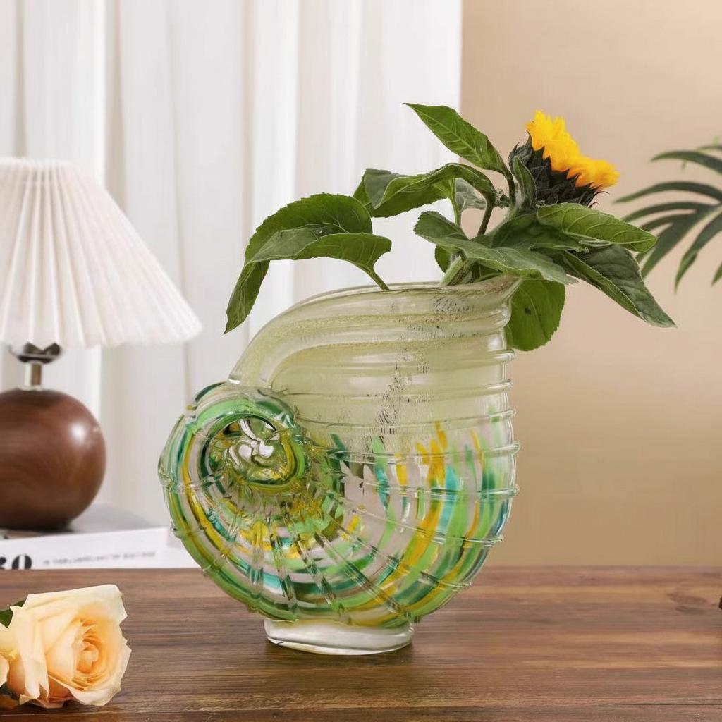 Side view of green and amber glass shell vase