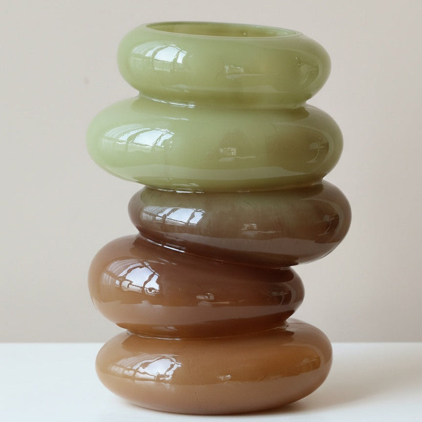 Close up of green and amber glass stacked ring vase