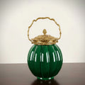 Green ceramic ribbed decorative jar with ornate gold-tone lid and handle