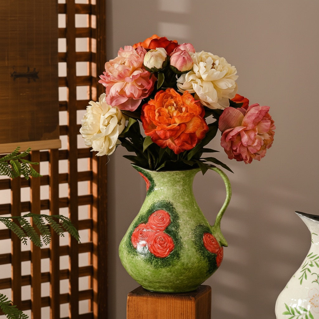 Floral ceramic pitcher vase filled with artificial flowers on stand