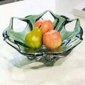 Green colored glaze sculptural centerpiece bowl with fruit on table