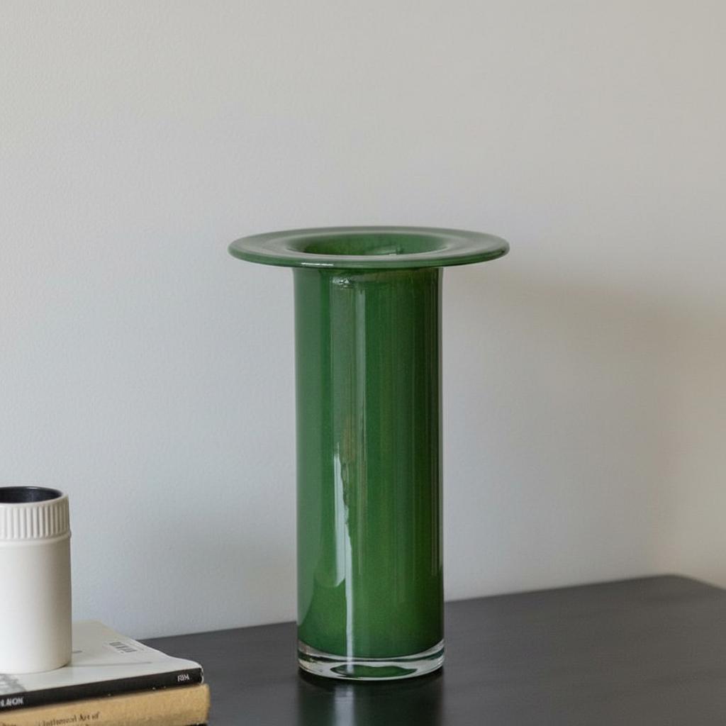 Empty green glass cylindrical vase on dark surface