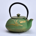 Green and gold cast iron teapot with dragonfly relief side view