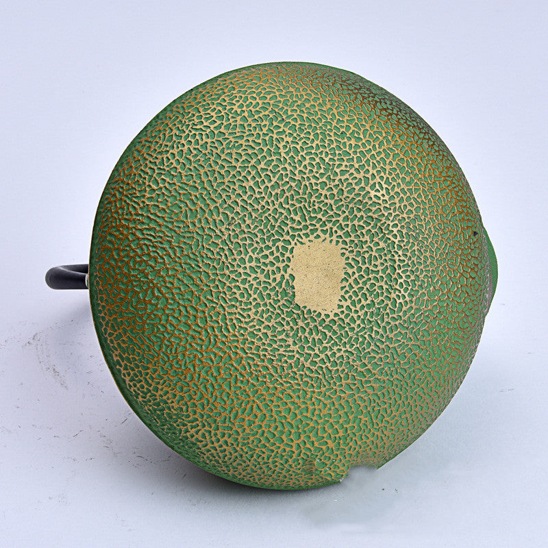 Bottom view of textured green cast iron teapot
