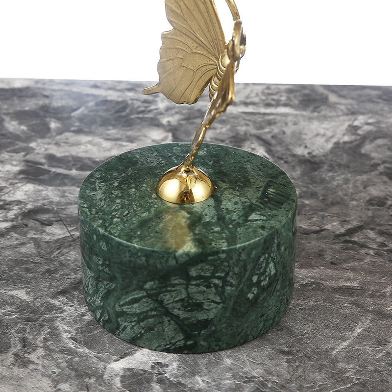 Detail shot of the polished green marble base and brass connection point of the sculpture