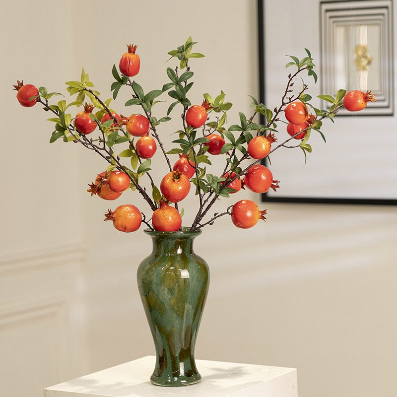 Green marbled glass vase with pomegranate branches