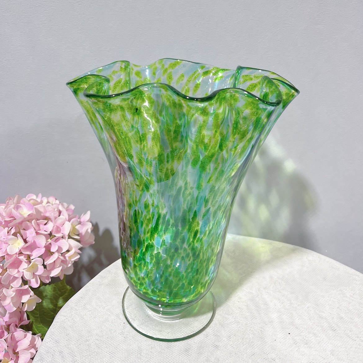 Wide ruffled rim green speckled glass vase
