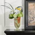 Green onyx footed chalice vase holding white and green floral arrangement