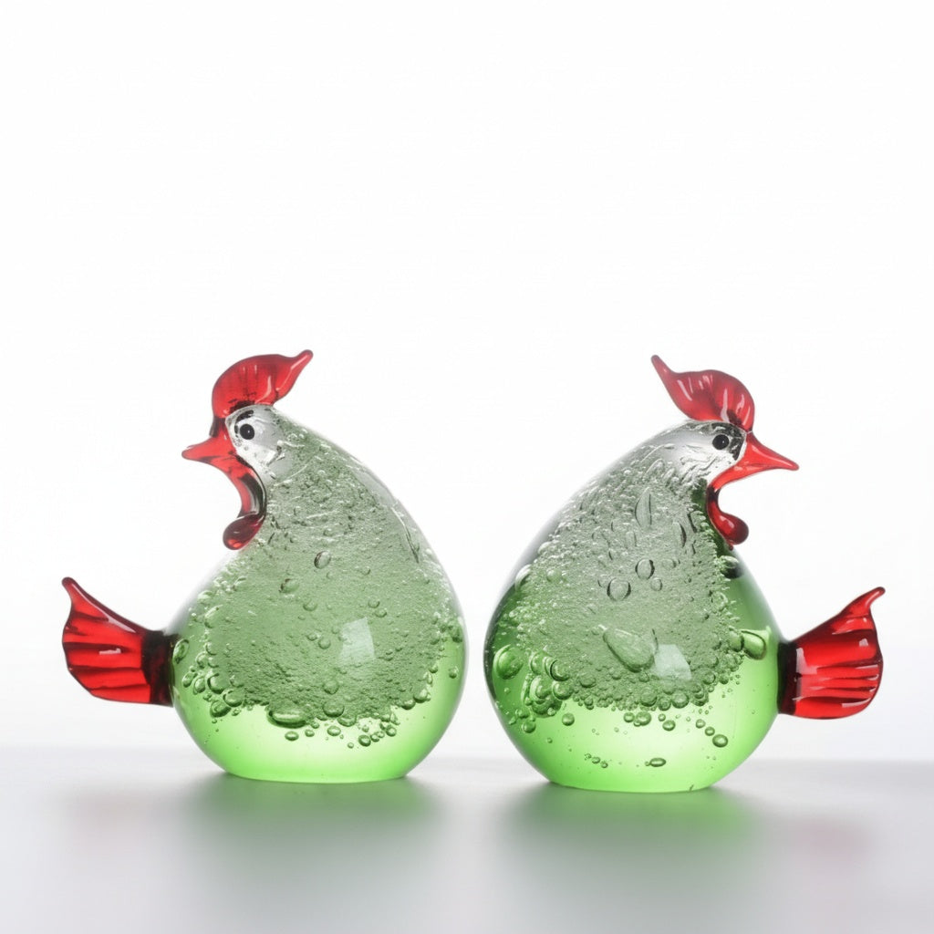 Pair of green and red glass rooster figurines displayed together