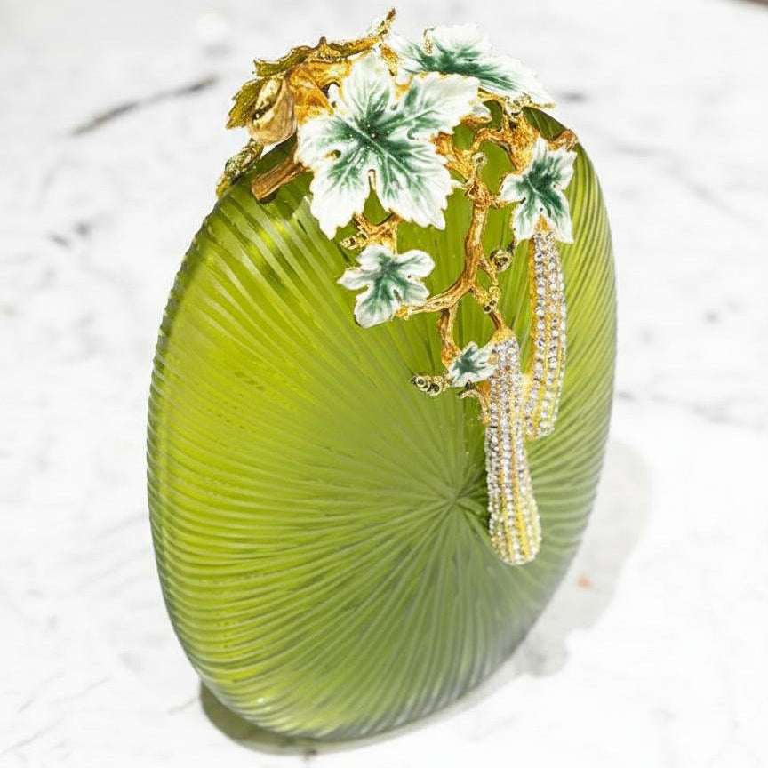 Close up of enamel leaves and crystal details on green vase