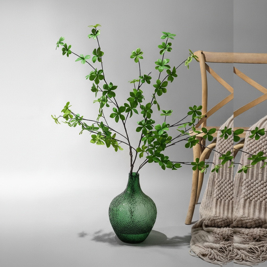 Green textured glass vase with branches on floor