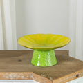 Front view of green and yellow glazed ceramic pedestal dish