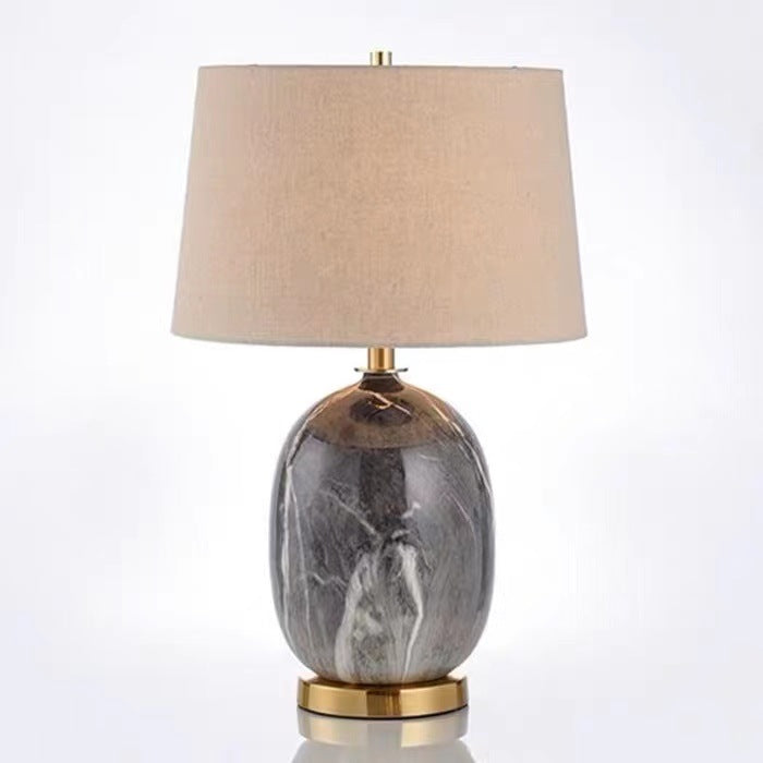 Studio view of grey marble ceramic lamp with brass base