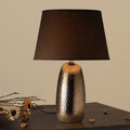Front view of hammered bronze ceramic table lamp with dark shade