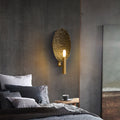 Hammered copper oval wall sconce illuminated in modern bedroom