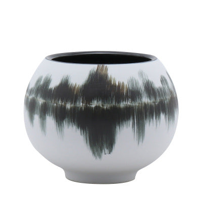 Medium ceramic orb vase with black interior and abstract exterior design