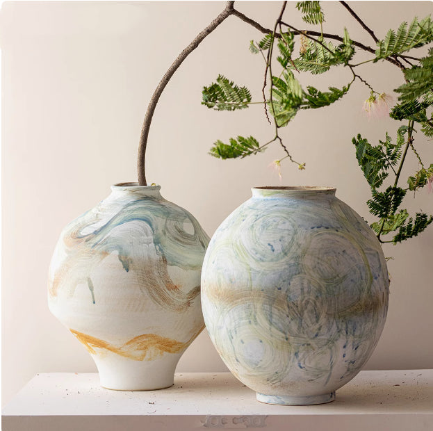 Group shot of hand painted ceramic vases with abstract blue and ochre swirls