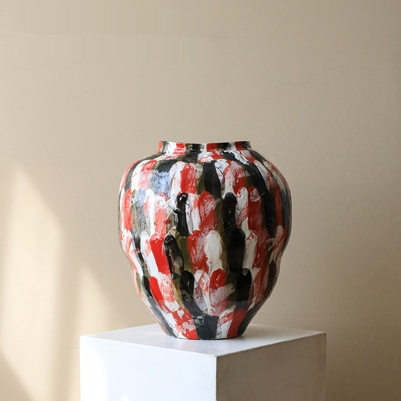 Abstract ceramic vase on white pedestal against neutral background
