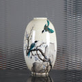Front view of cream ceramic vase with bird and blossom art