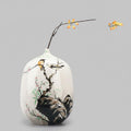 Front view of hand-painted ceramic vase with styled branch insert