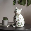 Front view of hand-painted ceramic cat figurine with green dots