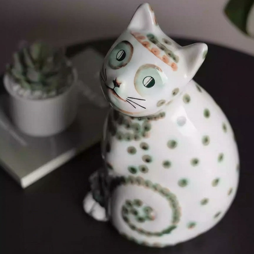 High angle view of glossy ceramic cat statue showing face details