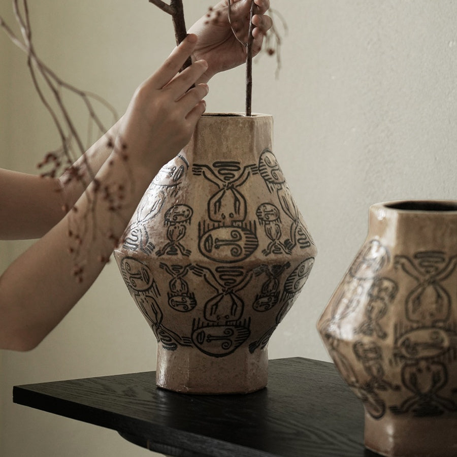 Lifestyle shot of arranging branches in the geometric ceramic vase