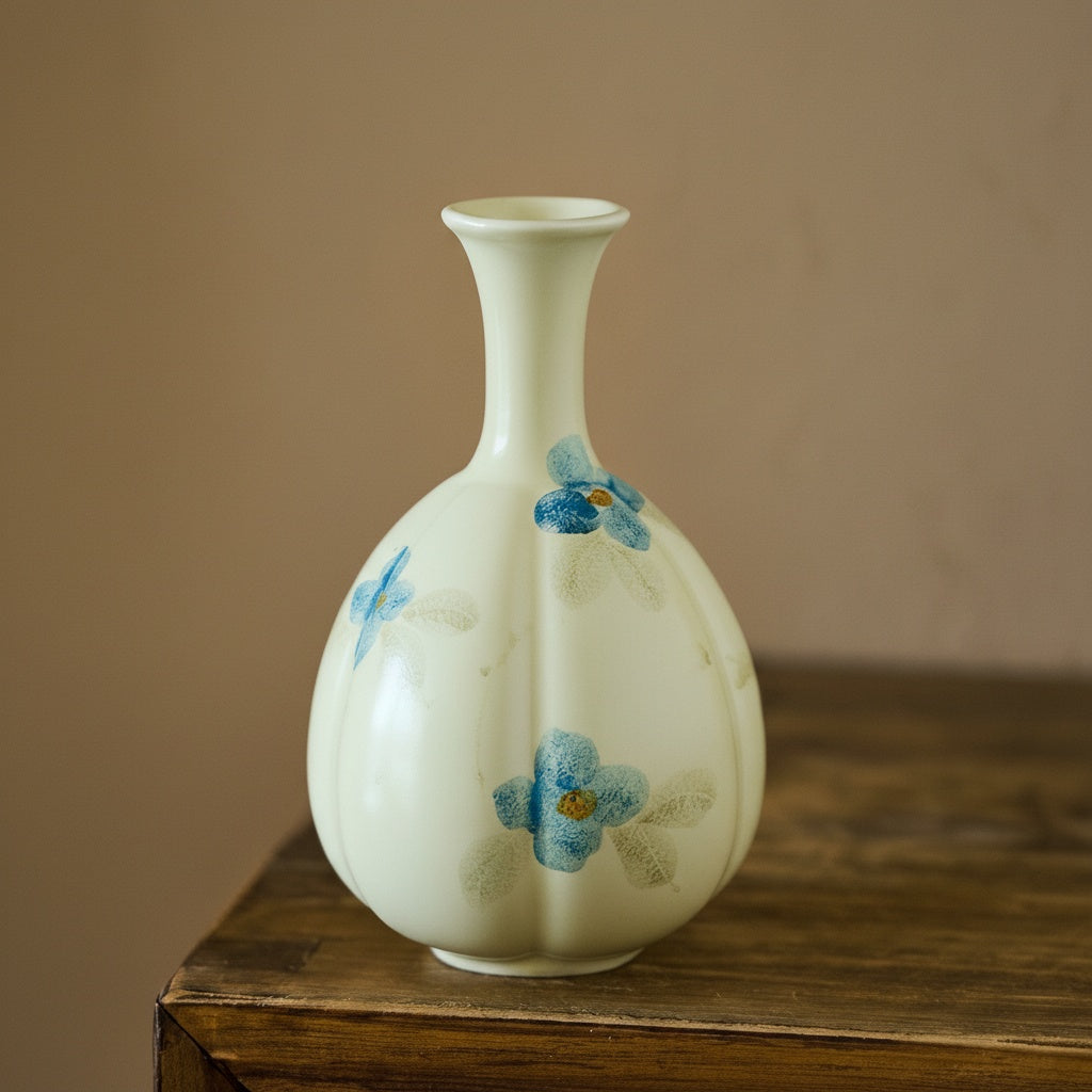 Empty hand-painted floral ceramic vase against neutral background