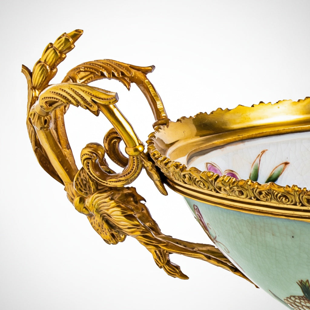 Detail of intricate gold-tone scrolling handle and rim