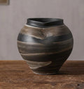 Close up of black textured ceramic vase with organic rim