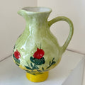 Hand-painted ceramic pomegranate pitcher with green glaze and yellow base