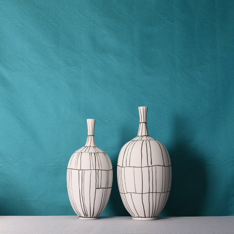 Set of two hand-painted white and black line ceramic vases side by side