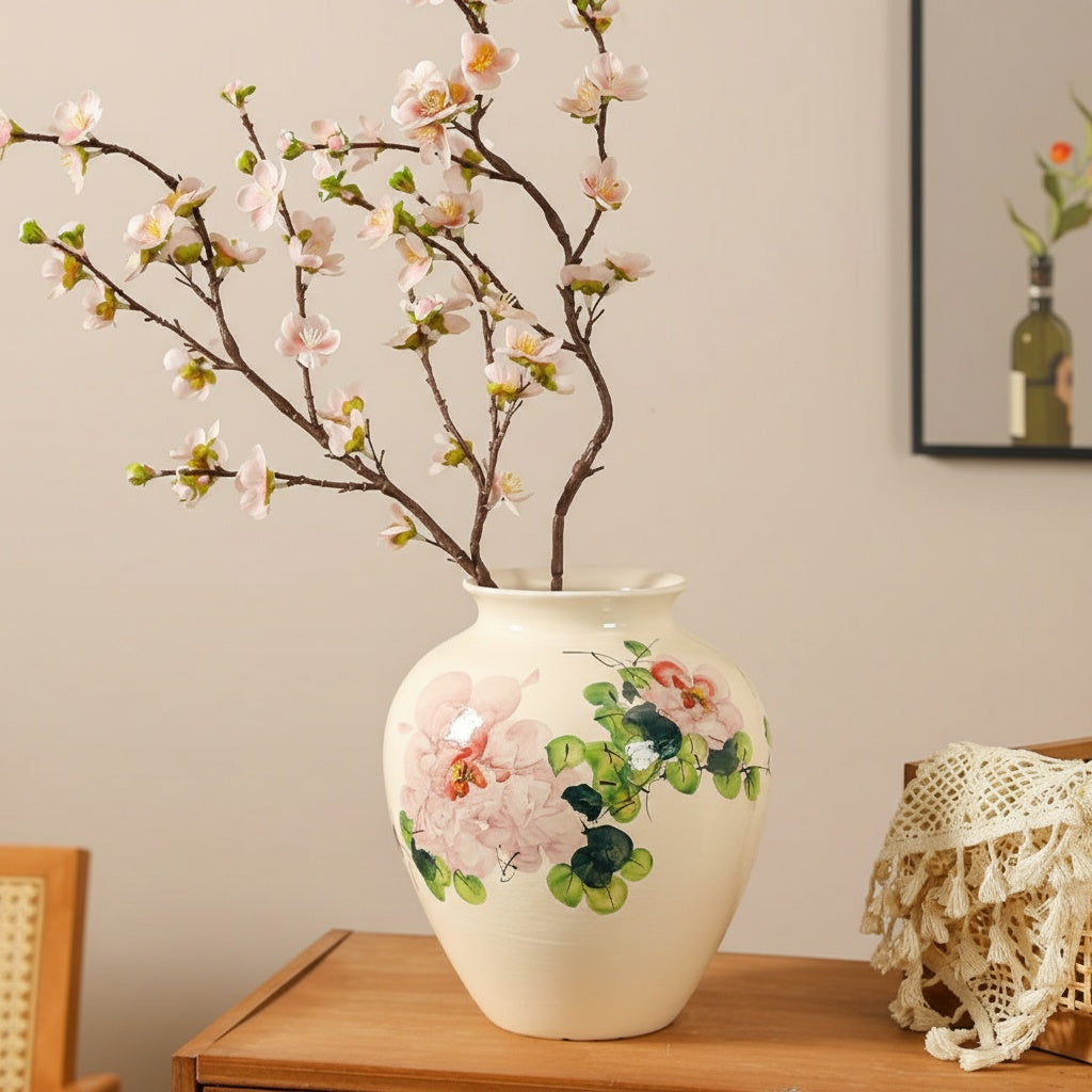 Ceramic vase with floral design holding cherry blossoms