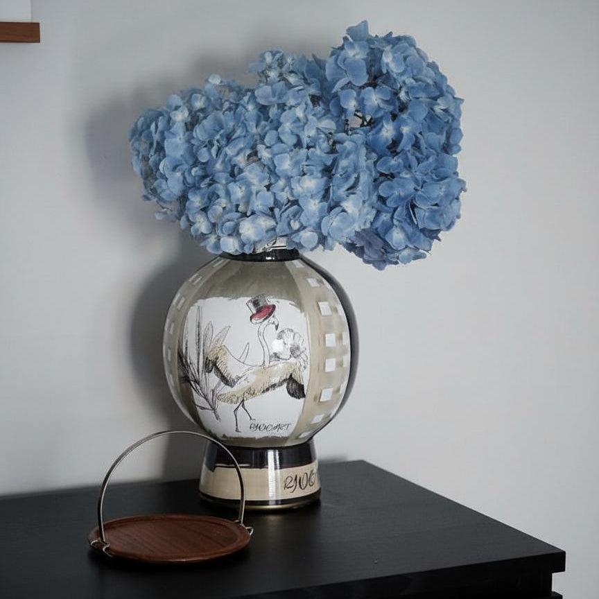 Porcelain vase with flowers on table showing flamingo side