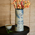 Stoneware mug being used as a vase with flowers next to a tea cup