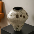 Front view of textured ceramic vase with abstract floral pattern