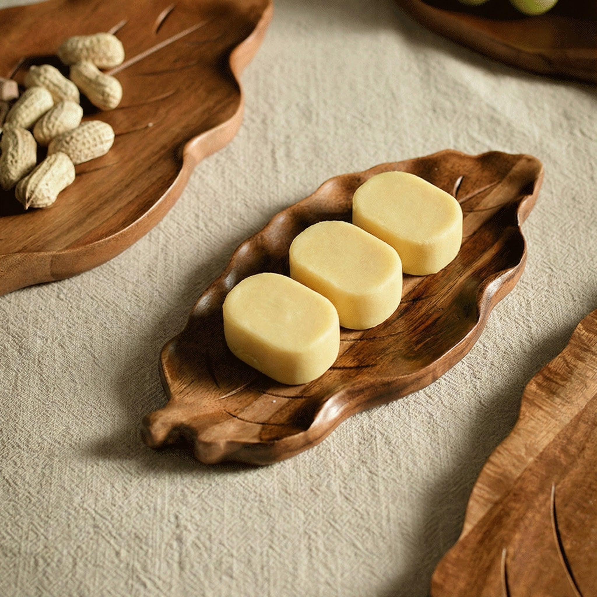 Close up detail of small cakes served on a carved wooden leaf plate