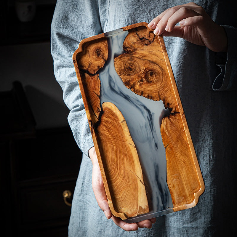 Person holding the handcrafted burl wood and resin tray showing scale and satin finish
