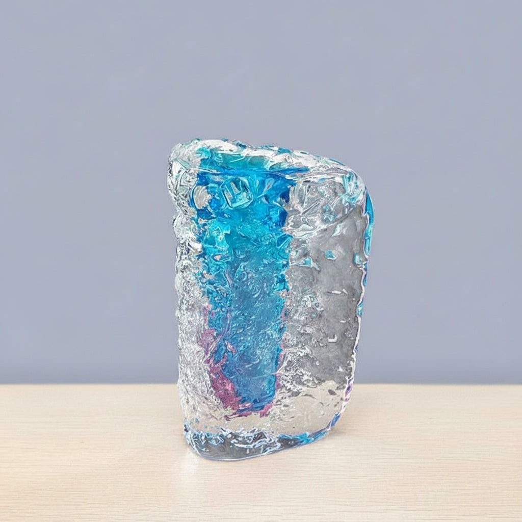 Angled view of thick glass vase with organic ice texture and blue interior