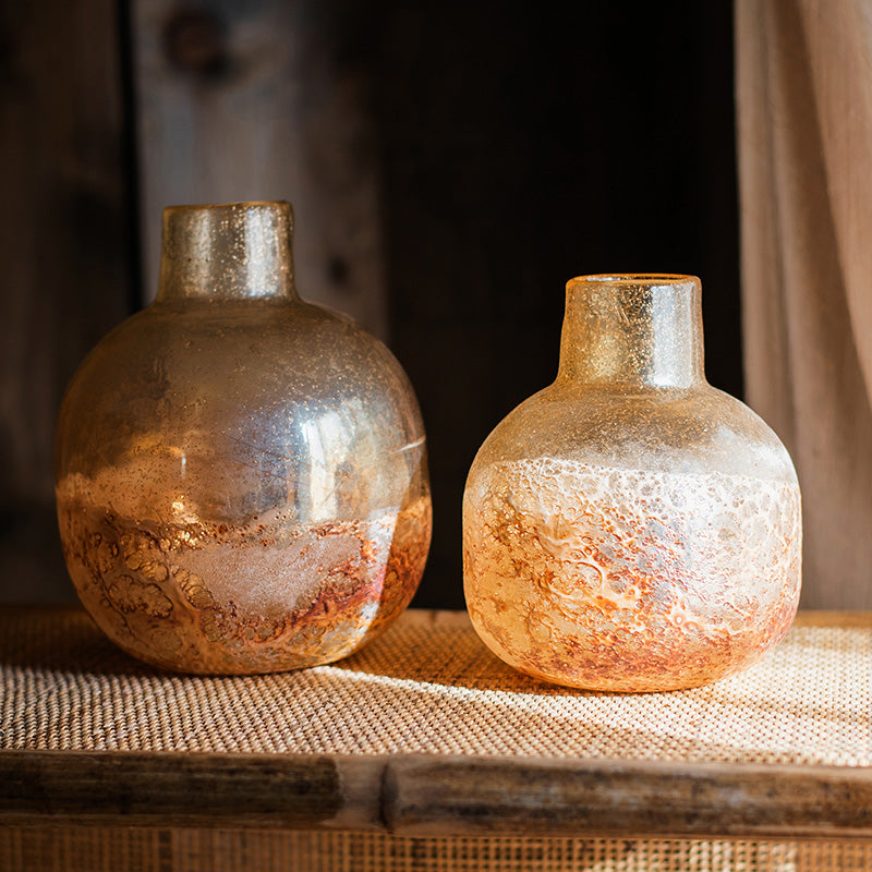 Two iridescent amber glass vases displaying texture differences