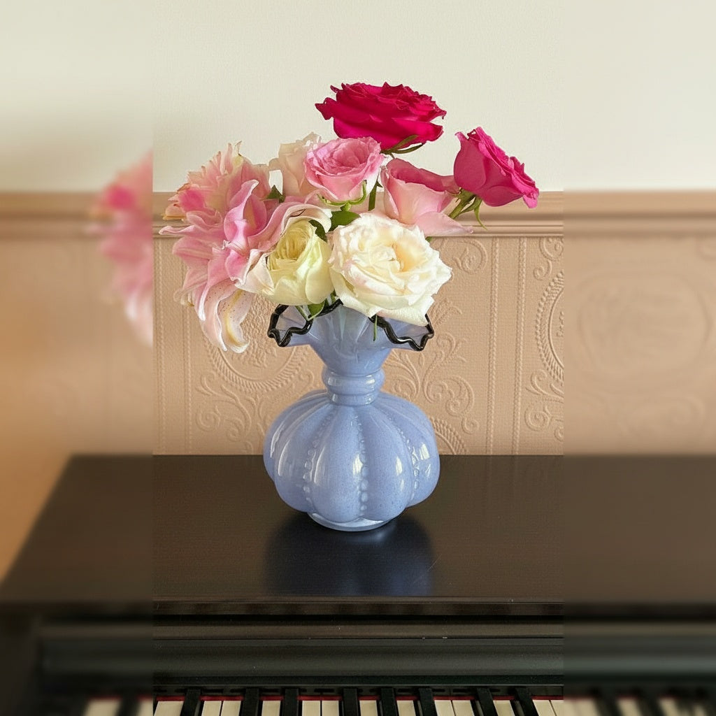 Lavender glass ruffled vase with roses on piano