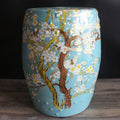 Front view of blue ceramic drum stool with bird and blossom art