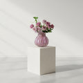 Person holding lilac bubble glass vase with roses