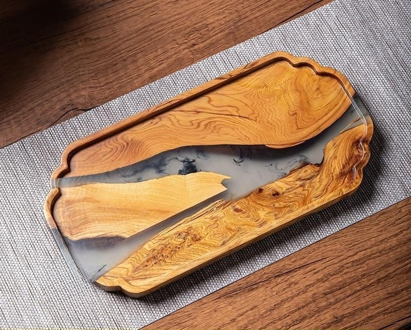 Close up of natural burl wood grain knots and swirling resin detail on serving board