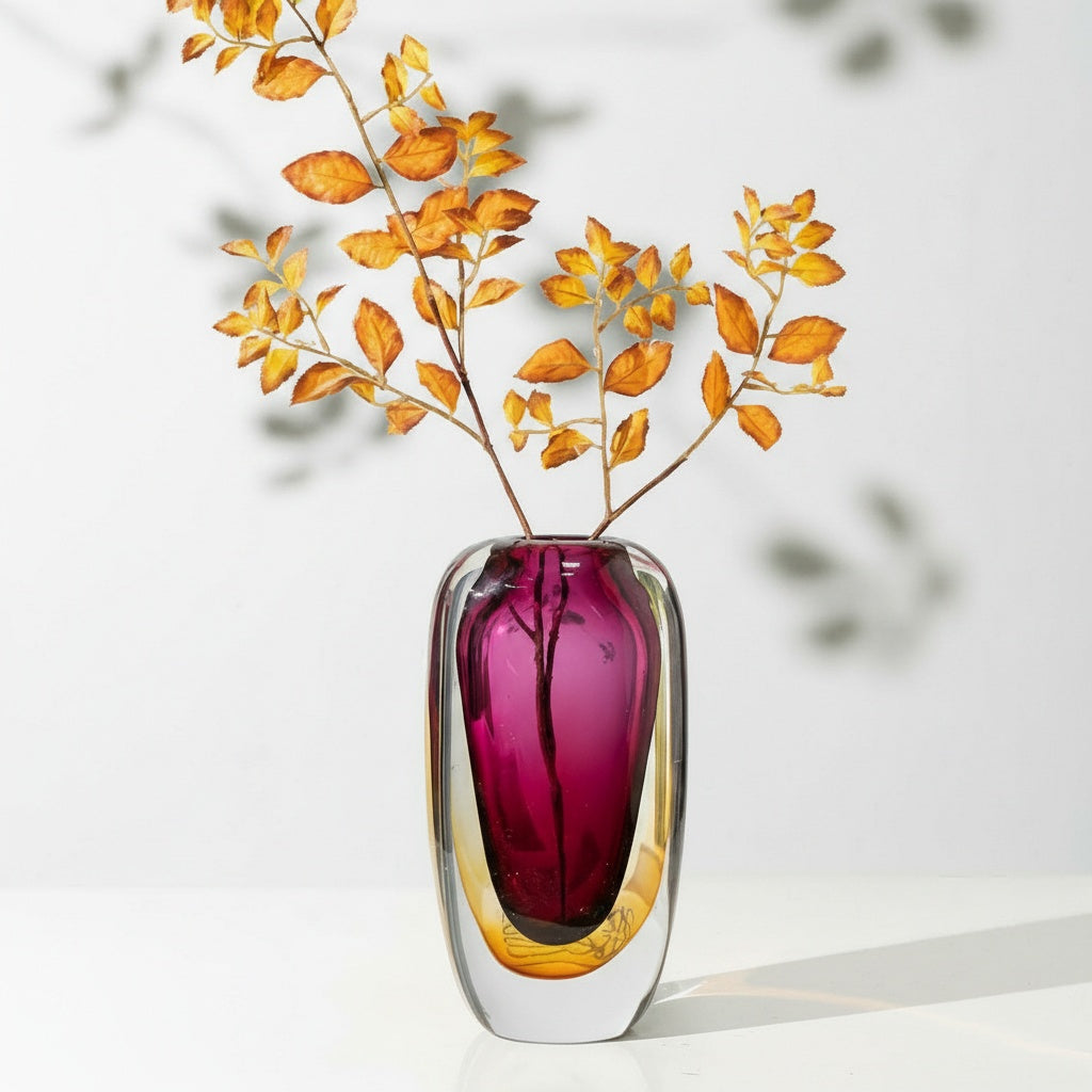 Lifestyle shot of magenta and amber vase with autumn leaves