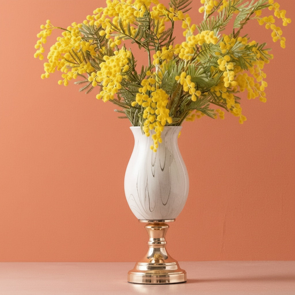 Marble pattern ceramic pedestal vase with yellow flowers on a gold-tone base